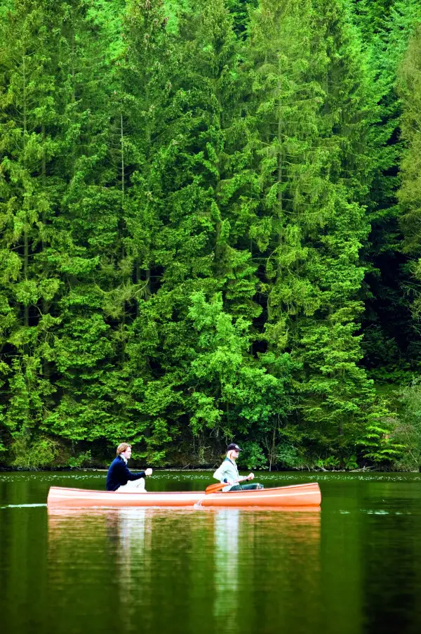 kanovaren in een houten kano in groene omgeving