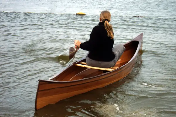 eenpersoons houten kano op water