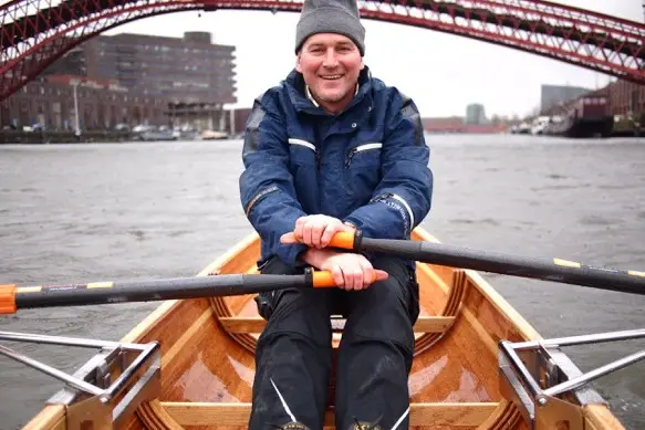 Man roeit houten wherry